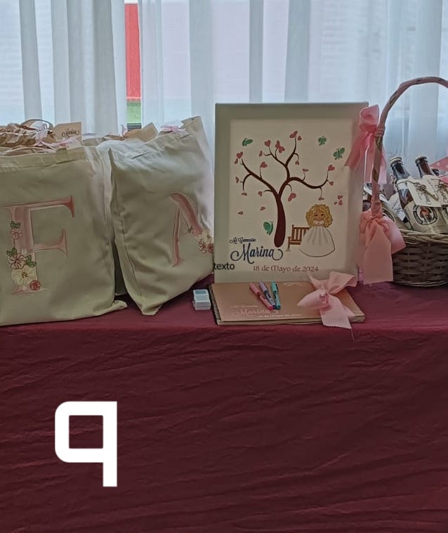 Mesa con árbol de huellas, libro de firmas y regalos comunión de Marina